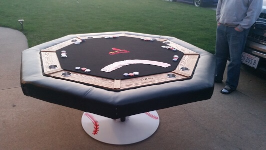 Eleghant Poker Tanle made with a steel stand/pedestal, custom team logo embroidered into the felt, solid oak trim around playing surface, stainless steel cup holders, and leather cushion. No corners are cut on these and they do take months to produce. Mes