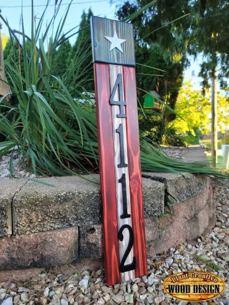 This address sign displays 4-6 numerical characters on our 5.25" x 30" vertical flag-themed base sign. The stripes, stars, and union are all cut out, sanded, colored, and assembled by hand. We put the numbers on top after we cut them out and paint them. 