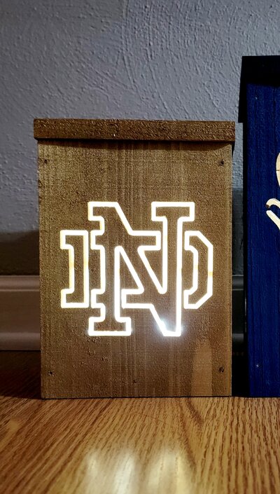 A Quincy Notre Dame lantern made of cedar. Lights and batteries included. If you want QND on 1 the side, it will be $15 per side that will be payable at time of pickup. 